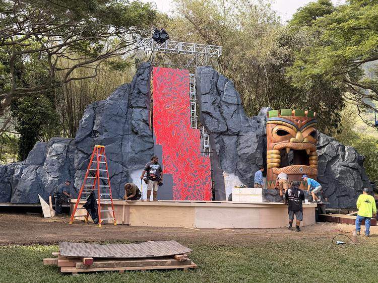 Crew building a sculpted volcano set with a custom LED lava-flow wall for a film production